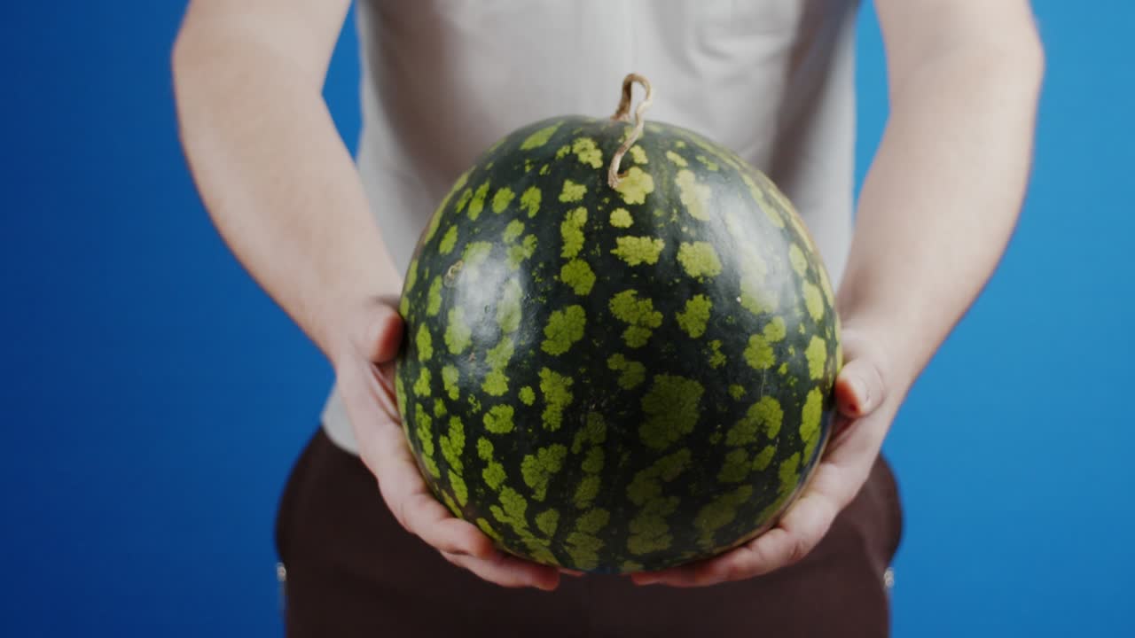 익은 수박을 들고 있는 남자.
