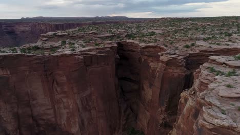 A-4K-rotating-drone-shot-of-the-"Fruit-Bowl",-a-famous-highlining-area-found-deep-in-the-heart-of-Moab’s-share-of-the-Colorado-Plateau,-along-a-remote-section-of-Mineral-Canyon,-in-Utah