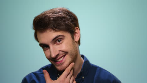 Man-flirting-with-camera-on-blue-background.-Portrait-of-bearded-man-biting-lips