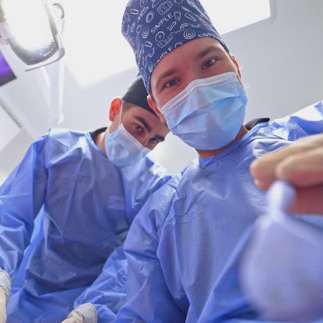 professional dentist treats tooth. assistant helps stomatologist in dental clinic. doctors use modern methods of treatment. view from below.