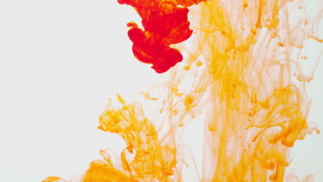 Orange-Paint-Or-Dye-Dropped-Into-Water-Against-White-Background-To-Create-Swirling-Colourful-Smoke-Background-7