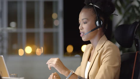 Young-African-American-woman-works-late-in-a-business-office-setting-with-copy-space