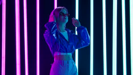 stylish woman with headphones in neon light