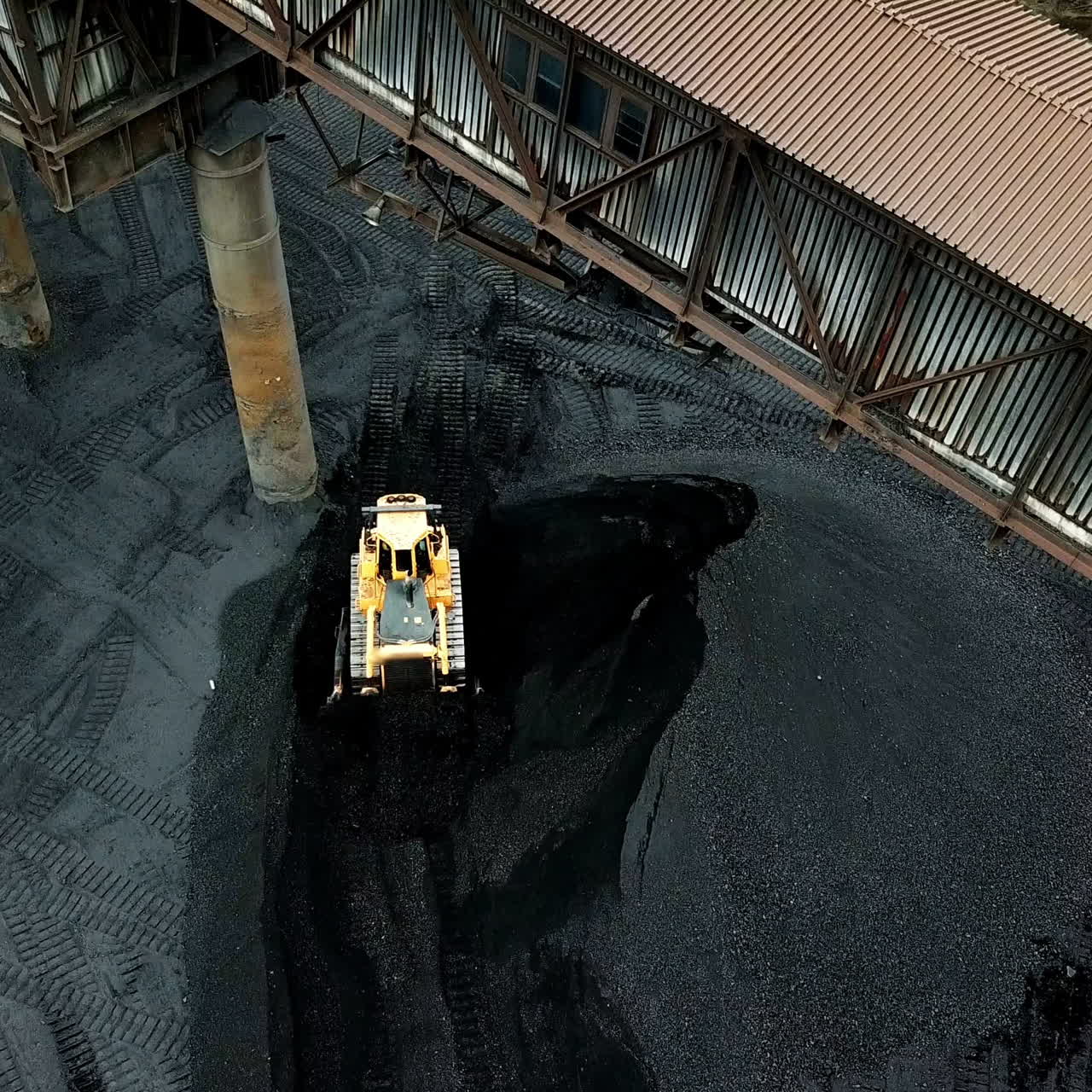 Bulldozer sorts coal. Extractive industry, anthracite. Coal industry. Aerial view.