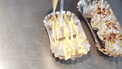 creamy cheese on dumplings in a food stall