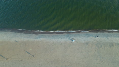 top down aerial over a fishing boat sails on the calm baltic sea, the rolling sea and clear, poland