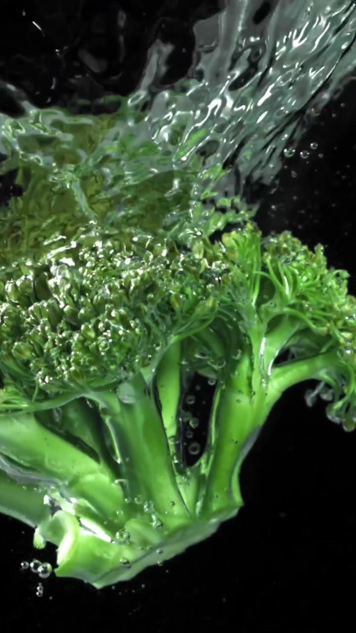 Broccoli verdi freschi che schizzano nell'acqua al rallentatore