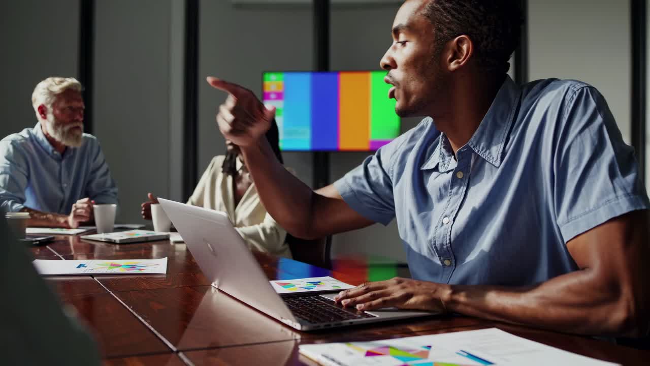 A dynamic office meeting scene captured from a side angle, highlighting a discussion with vibrant