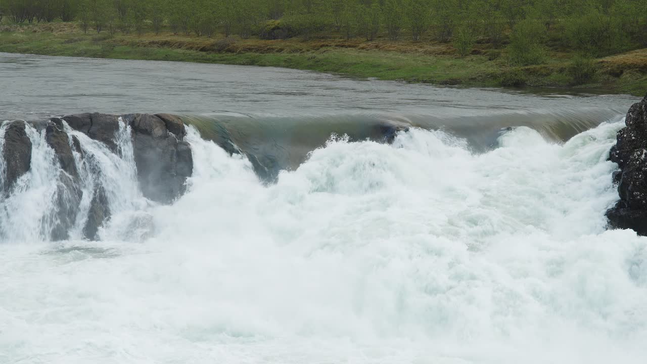 거친 풍경의 한가운데에 있는 바위 위에 폭포로 흐르는 격렬한 강