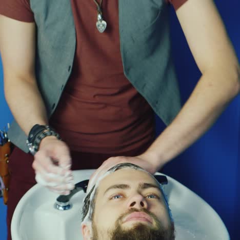 peluquero hombre lavando cabello masculino en una barbería 02