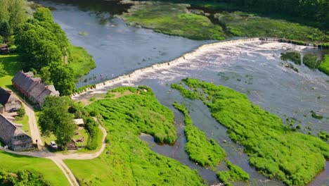 cinematic aerial tele shot, europe’s widest waterfall flowing through latvia