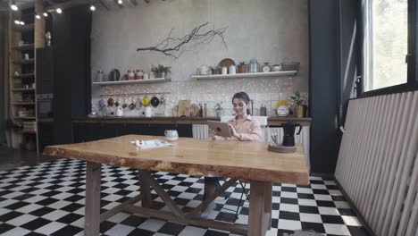 mujer trabajando en una tableta en una cocina moderna