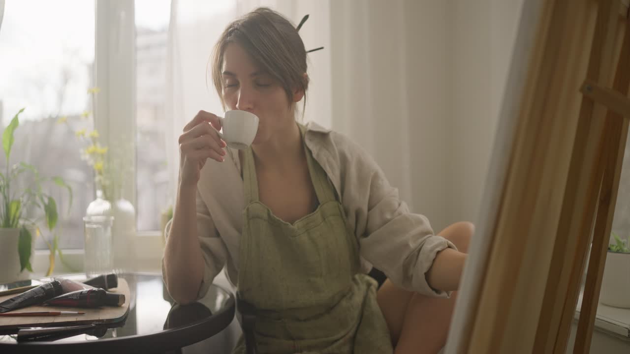 커피 휴식을 즐기고 있는 집에서 그림을 그리는 여자