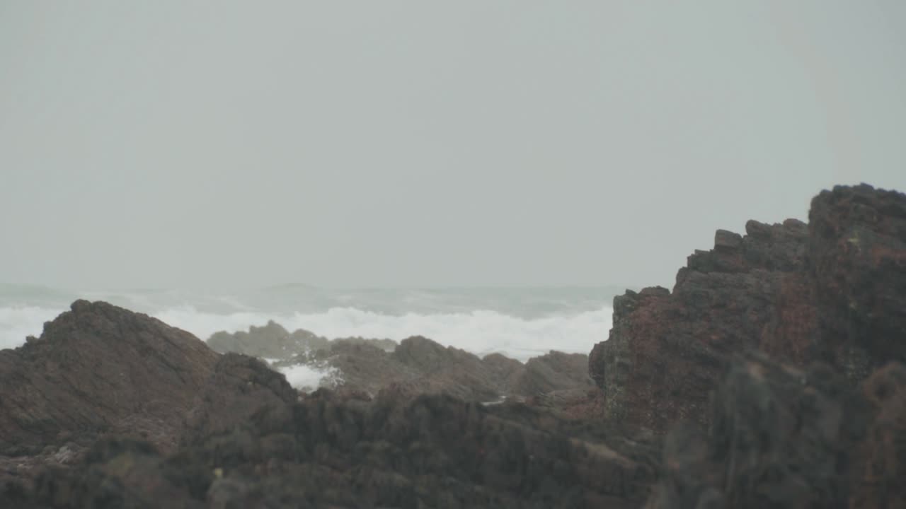 grandes rocas en la playa con olas de fondo
