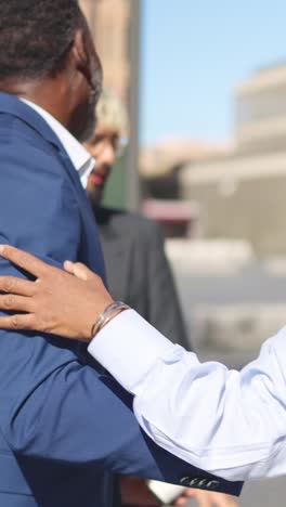business people shaking hands and embracing in the financial district
