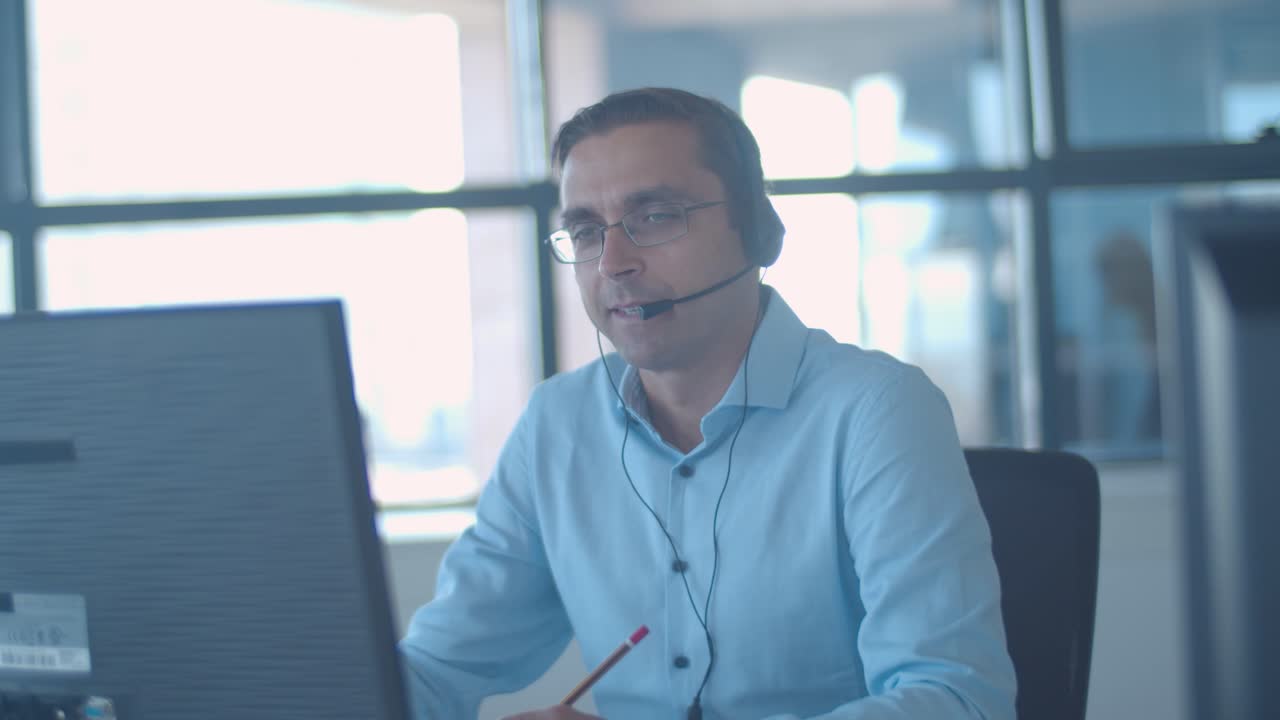 consultor masculino serio en auriculares hablando en el micrófono