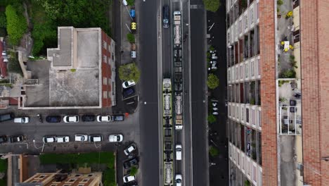 Drone-Descends-as-Public-Tram-Drives-to-next-Station-in-Rome,-Italy