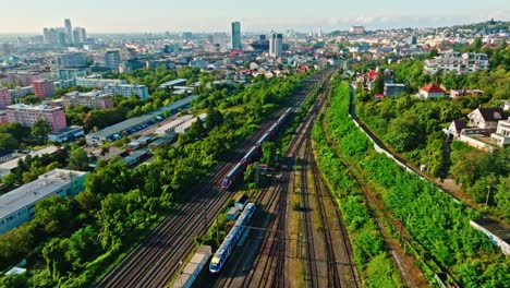 aerial view of railway lines running through the green outskirts of bratislava, leading the train into the city