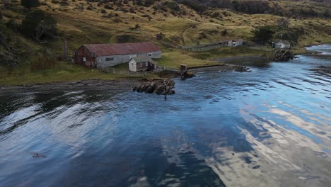 woman walking on rocks of a rural barn by the sea