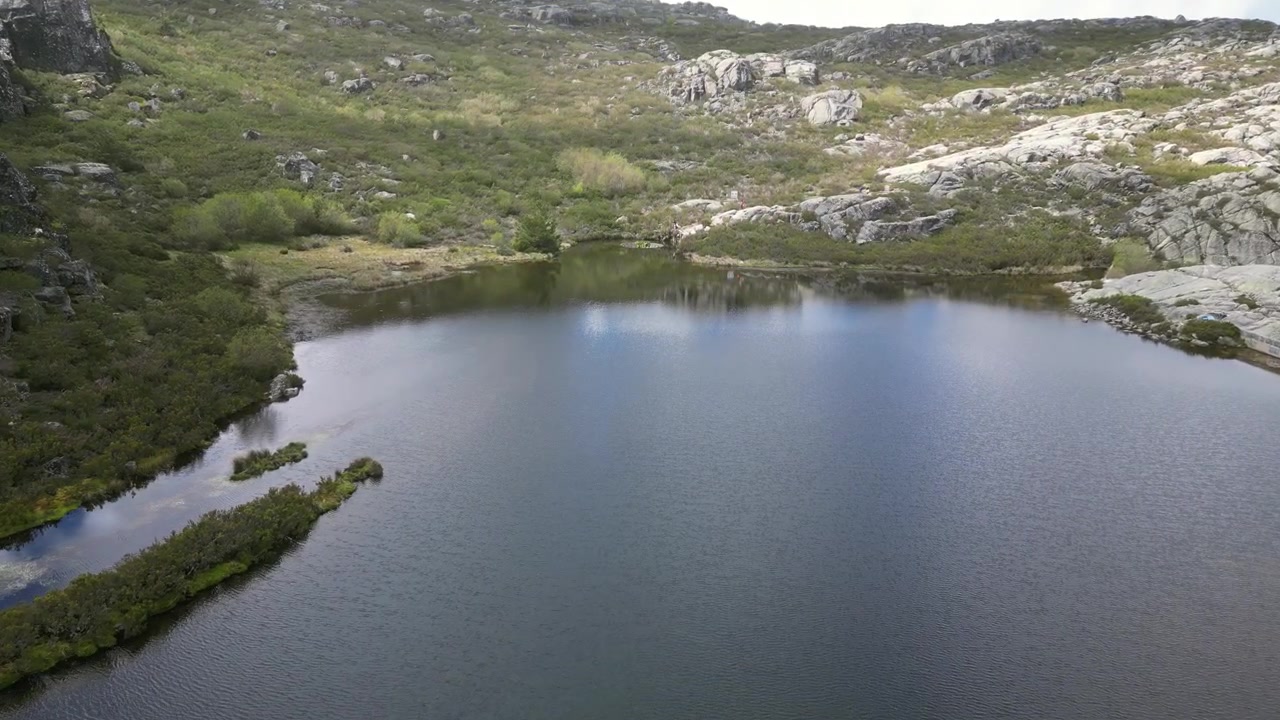 Portekiz, Covão dos Conchos'un havadan drone görüntüleri: Serra da Estrela manzarasıyla çevrili, eşsiz dairesel bir savaklı dağ gölü. Seyahat ve doğa projeleri için idealdir.