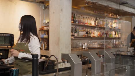 woman customer receiving food from waitress with face mask on counter then next customer come and order food by social distancing rule for new normal lifestyle in restaurant during covid pandemic.