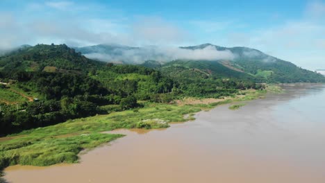 Großer-Fluss,-Der-Durch-Die-Bergregion-Mit-Nebligen-Bergen-Fließt,-Drohnenaufnahme