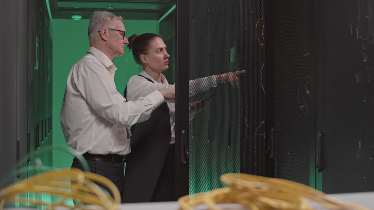 Two IT Professionals Inspecting Servers in a Data Center