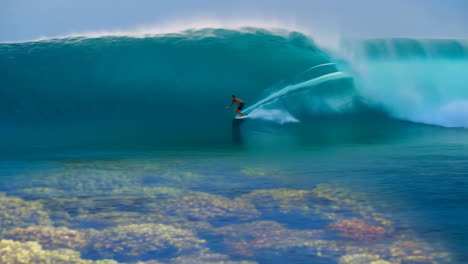 surfer riding a massive ocean wave over a coral reef