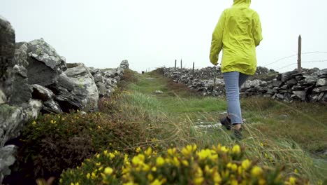 Slowmotion-of-outdoor-girl-in-yellow-jacket-walking-through-heavy-rain-in-nature