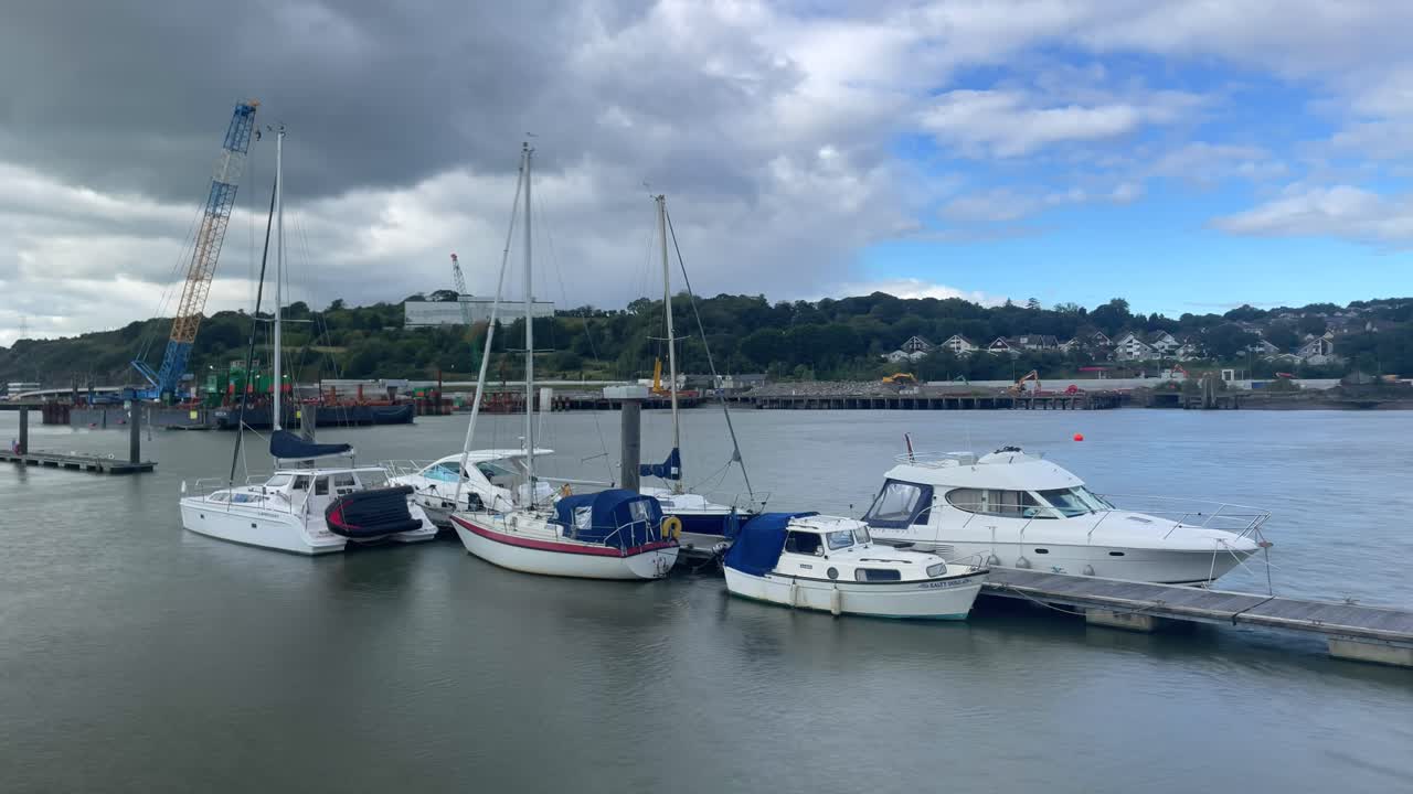Waterford City Quays Ireland Timelapse boats moored construction on North Quays in background strongly flowing river on summer day