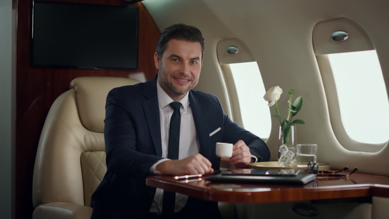 CEO sorridente che posa da solo al finestrino dell'aereo. Uomo di successo che si gode un viaggio aziendale