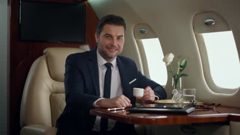 smiling ceo posing alone at airplane window. successful man enjoy corporate trip