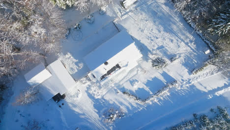 aerial view rotating above partly snowy photovoltaic cells, on a house roof