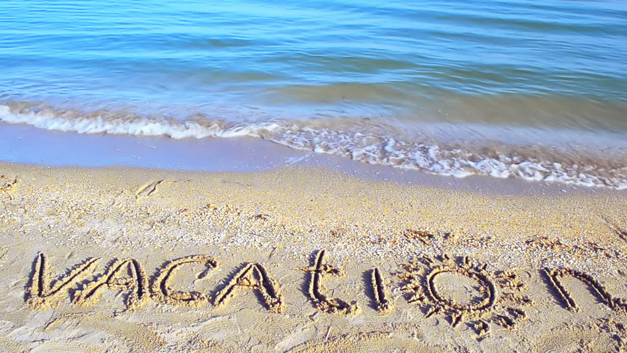 The inscription Vacation on sand. Inscription on sand