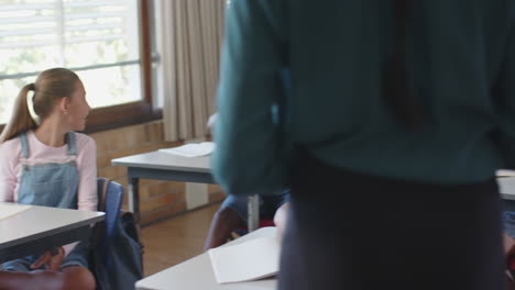 in school, boy raising hand and another boy asking question in classroom