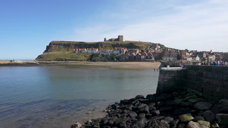 Hafen-Von-Whitby-In-North-Yorkshire-England-Im-Sommer-Mit-Einer-Vorbeifliegenden-Möwe-Und-Der-Abtei-Auf-Den-Klippen-In-Zeitlupe