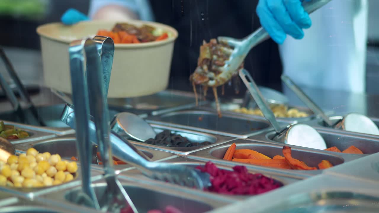 Chef con i guanti che prepara un pasto sano al bancone del servizio di ristorazione