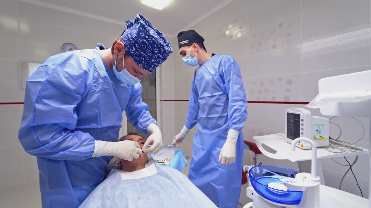 Dentist is treating a patient in a modern dental office. Stomatologist prepares woman's mouth before the tooth treatment. Dentistry concept.