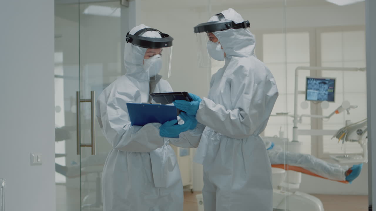 el dentista le da una pastilla a la enfermera dental antes de la consulta