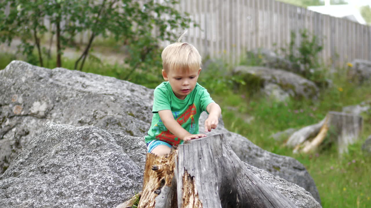 Junger, unschuldiger Junge spielt draußen in der Natur, 4K Zeitlupe.