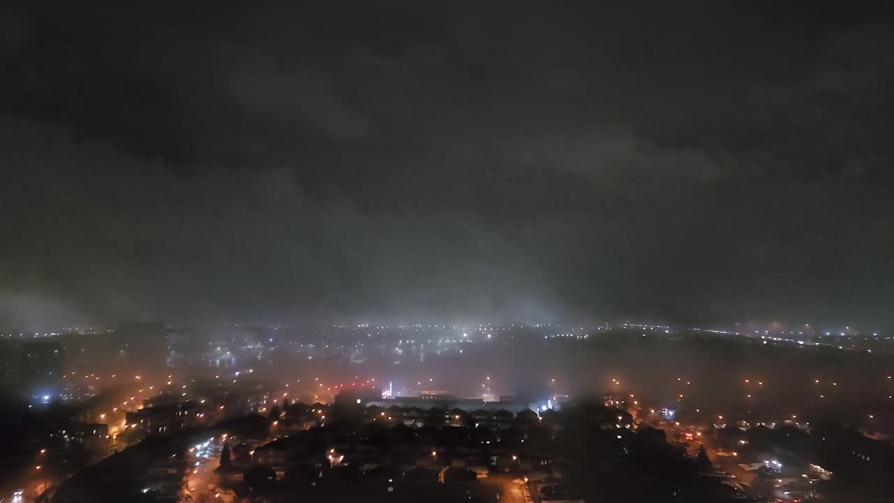 Toronto city lights in dense fog at night, moody and mysterious urban scene