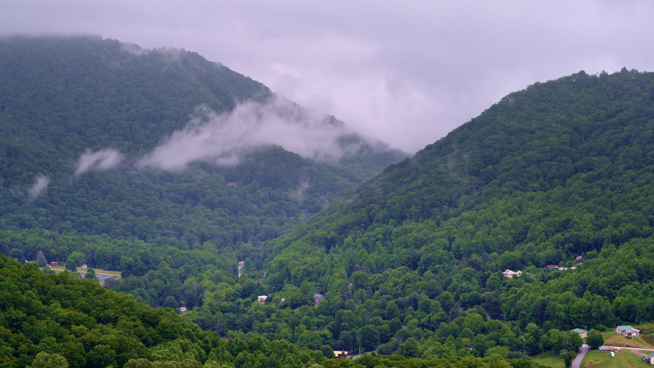 Aerial cinematic view above mist cascading through the Smokies.