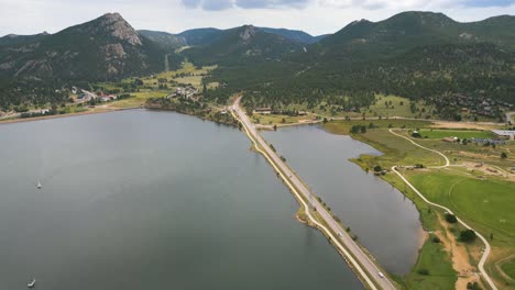 Driving-On-The-Road-Over-Lake-Estes-In-Estes-Park,-Colorado,-USA-With-View-Of-Mount-Olympus-In-Background