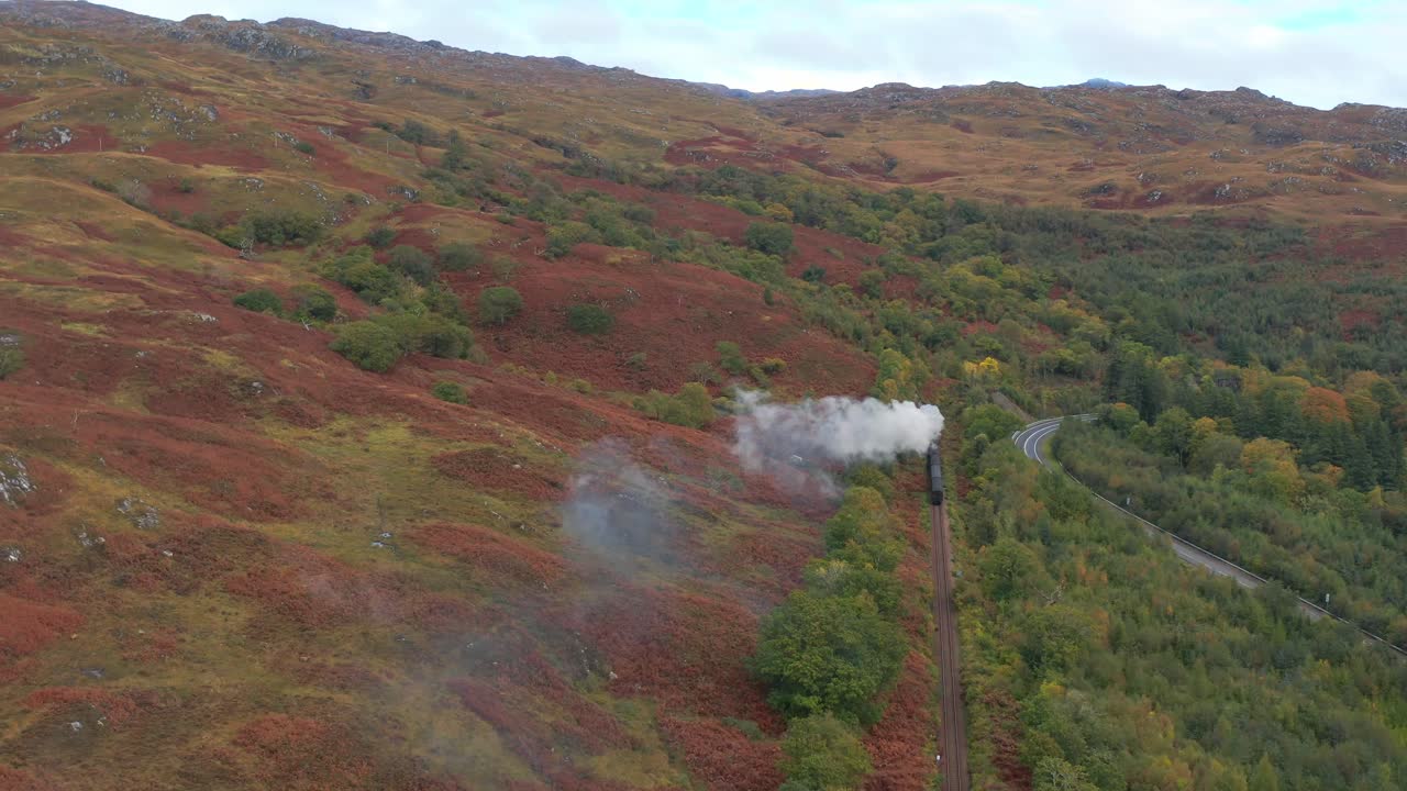 дронный вид поезда гарри поттера в шотландских горных районах. знаменитый паровой поезд якобита.