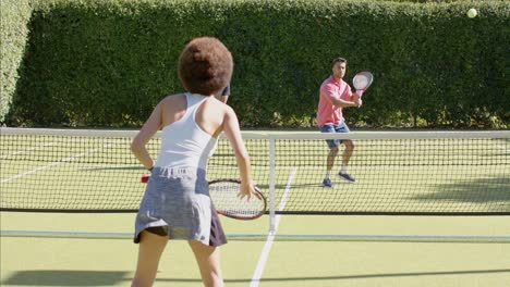 happy diverse group of friends playing tennis at tennis court