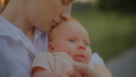 mother hugging newborn at sunset