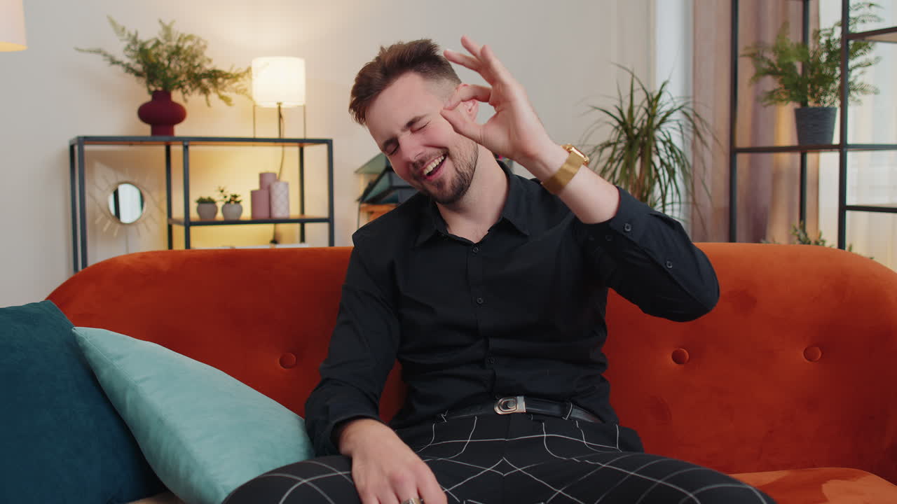 joven adulto feliz y alegre mirando con aprobación a la cámara mostrando un gesto de ok, positivo como una señal