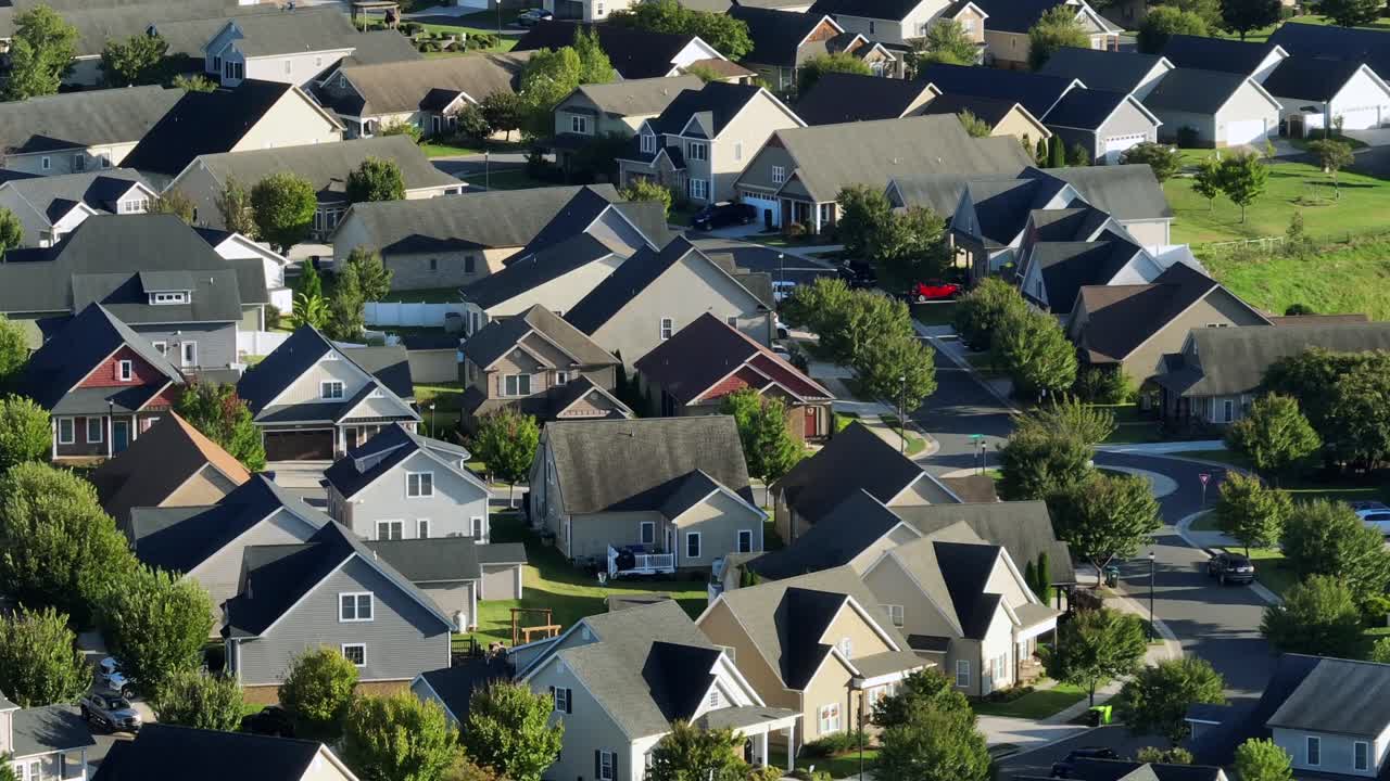 Classical american houses in new modern style at golden sunset. Green trees in well-maintained suburb district in USA at fall season. Aerial wide shot