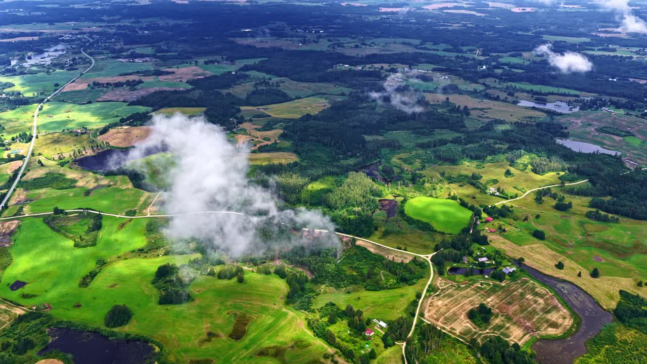 Drone view of a dense clouds over a countryside field with wild vegetations during daytime