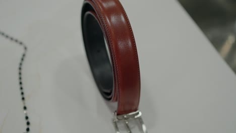 Classic brown leather belt with silver buckle on a white surface